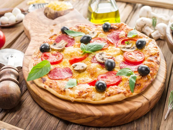 Pizza med champinjoner, salami och tomater. — Stockfoto