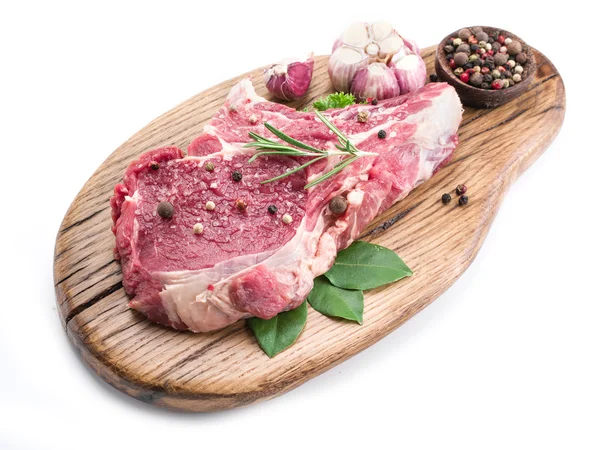 Beef steak with spices on the wooden cutting board. — Stock Photo, Image