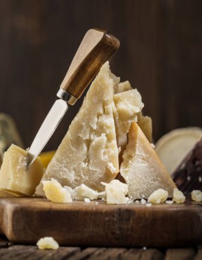 Kırsal ahşap tahtada parmesan peyniri tabağı ve bir bardak kırmızı şarap. Restoran menüsü kavramı.