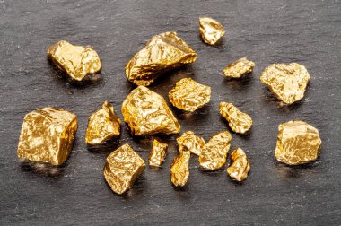 Altın külçeleri siyah taştan arka planda üst manzarada. Altın külçelerinin taklidi.