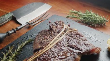 Biftek, otlu ve sarımsaklı servis panosuna yakın çekim. Üst görünüm.