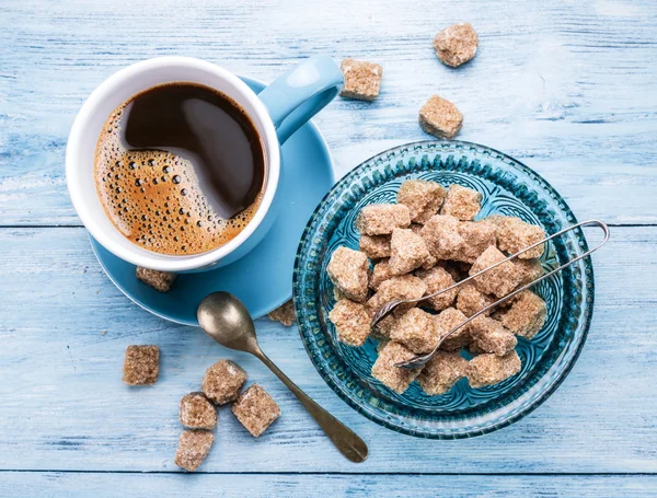 Taza de café y cubitos de azúcar de caña . — Foto de Stock