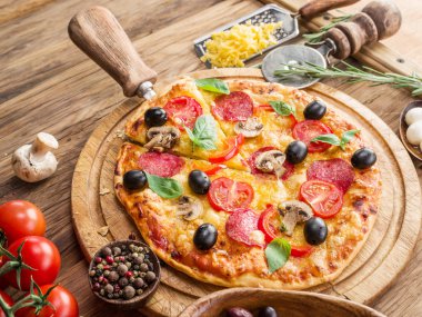 Mantar, salam ve domates pizza.