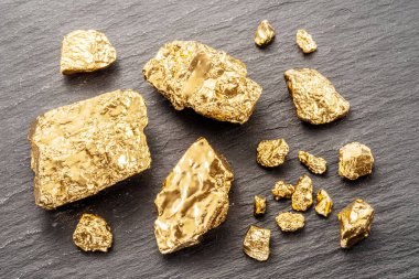 Altın külçeleri siyah taştan arka planda üst manzarada. Altın külçelerinin taklidi.