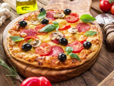 Mantar, salam ve domates pizza.