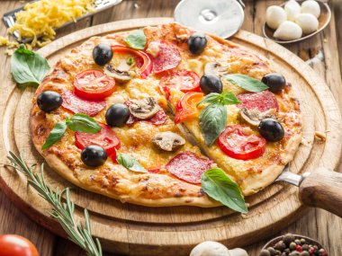 Mantar, salam ve domates pizza.