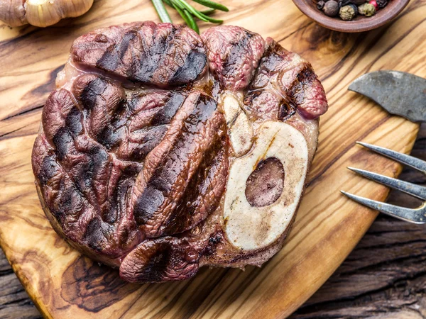 Rundvlees steaks met kruiden op een houten dienblad. — Stockfoto