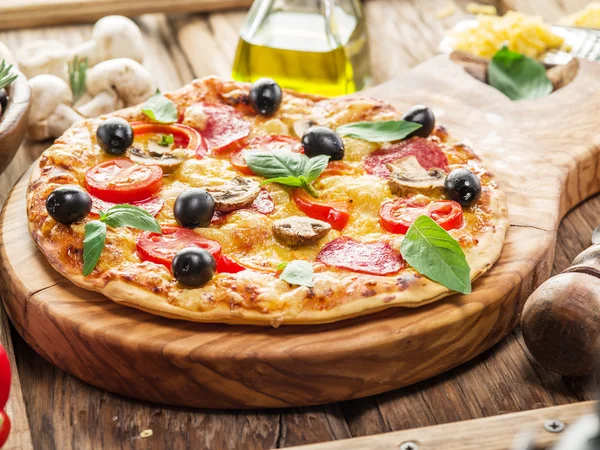 Pizza med champinjoner, salami och tomater. — Stockfoto