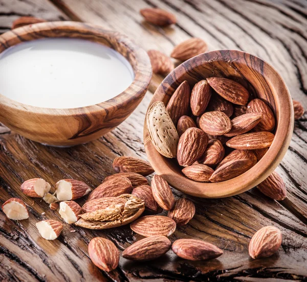 Mandelnüsse und Milch auf Holztisch. — Stockfoto