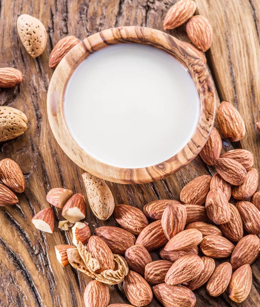 Mandelnüsse und Milch auf Holztisch. — Stockfoto