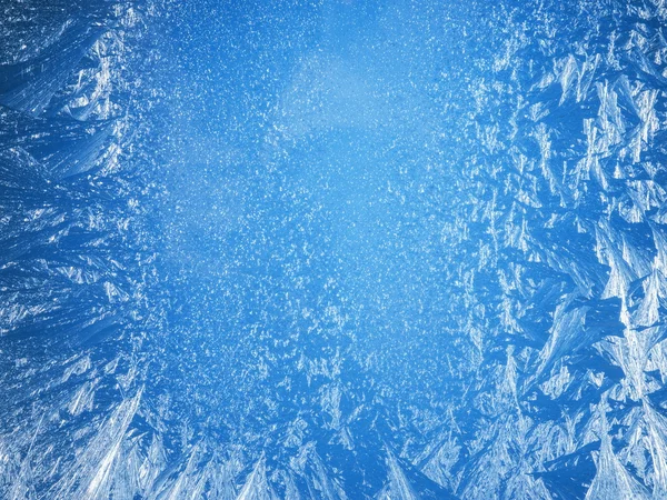 Ледяные узоры на краю замерзшего окна. — стоковое фото