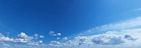Weiße Trümmerwolken am blauen Himmel. — Stockfoto