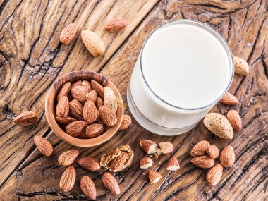 Badem fındık ve ahşap masa üzerinde süt.