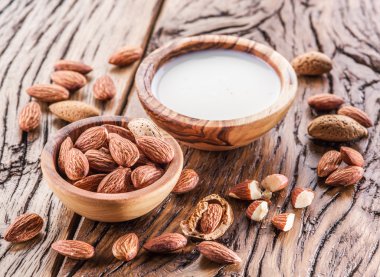 Badem fındık ve ahşap masa üzerinde süt.