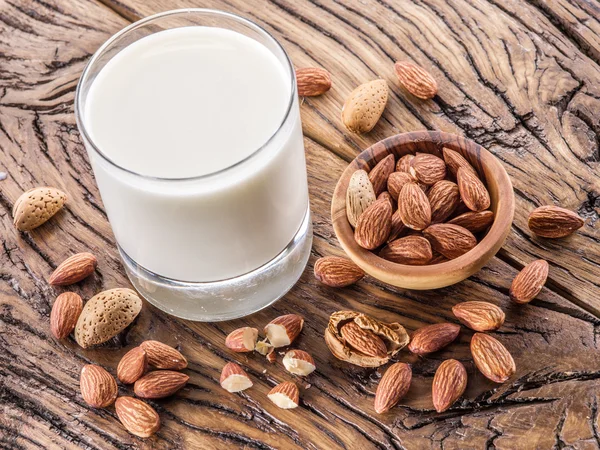 Mandelnüsse und Milch auf Holztisch. — Stockfoto