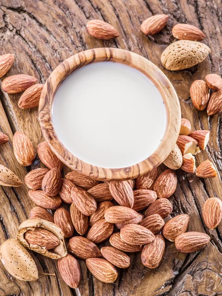 Mandelnüsse und Milch auf Holztisch. — Stockfoto