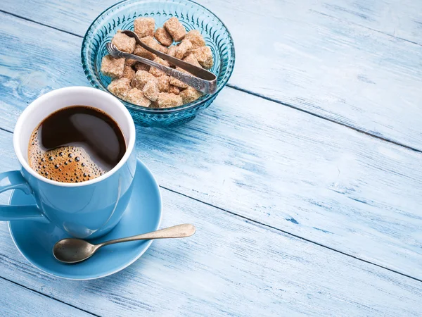 Taza de café y cubitos de azúcar de caña . — Foto de Stock