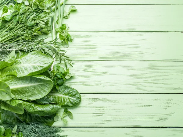 Hierbas verdes sobre el fondo de madera verde . — Foto de Stock