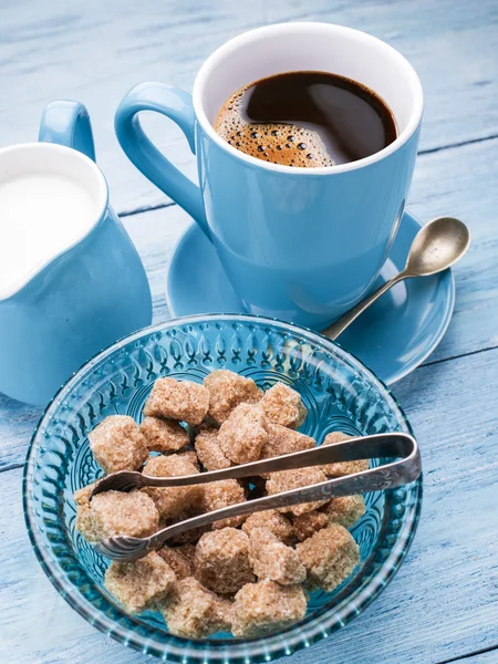 Xícara de café, jarro de leite e cubos de açúcar de cana . — Fotografia de Stock