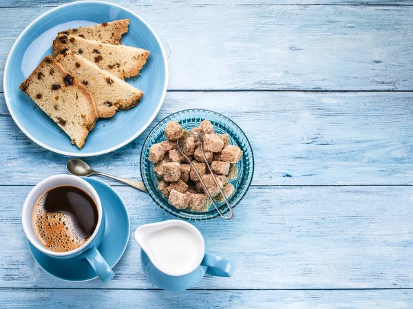 Tasse Kaffee, Milchkanne, Zuckerrohrwürfel und Obstkuchen. — Stockfoto