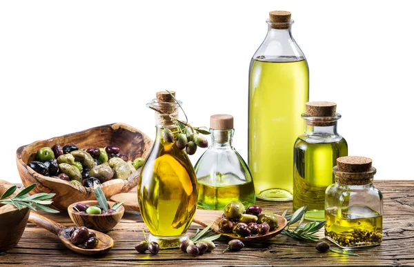 Aceite de oliva y bayas en la mesa de madera . — Foto de Stock