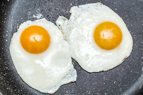 Fried eggs in the frying pan. — Stock Photo, Image