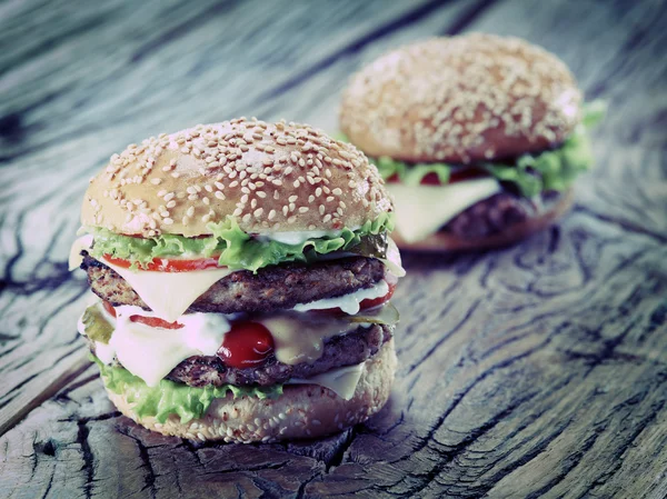 Hamburger on old wooden table. — Stock Photo, Image