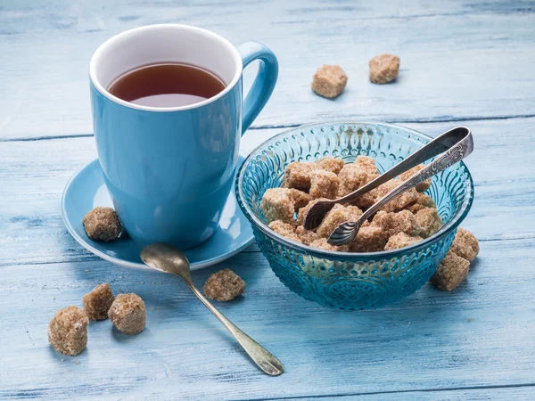 Tasse Tee und Zuckerrohrwürfel. — Stockfoto
