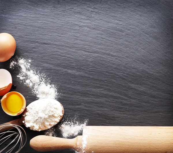 Dough preparation. Baking ingredients: egg and flour on black bo — Stock Photo, Image