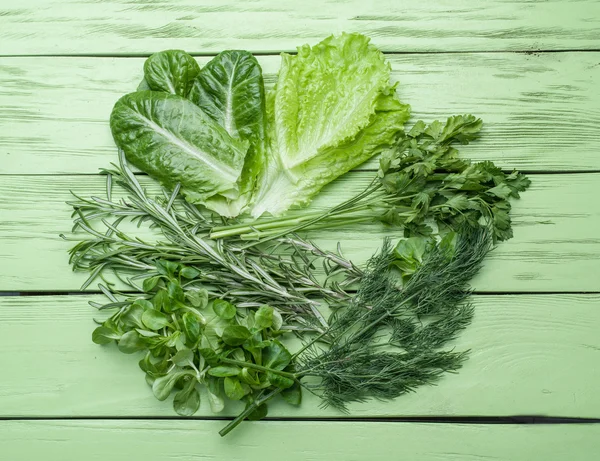 Green herbs on the green wooden background. — Stock Photo, Image