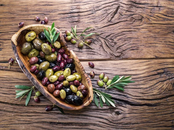 Весь стол оливки в деревянной чаше на столе . — стоковое фото