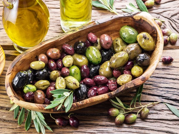 Aceitunas de mesa enteras en el cuenco de madera de la mesa . —  Fotos de Stock