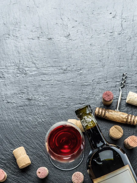 Botella de vino, copa de vino y sacacorchos en la pizarra de grafito . —  Fotos de Stock