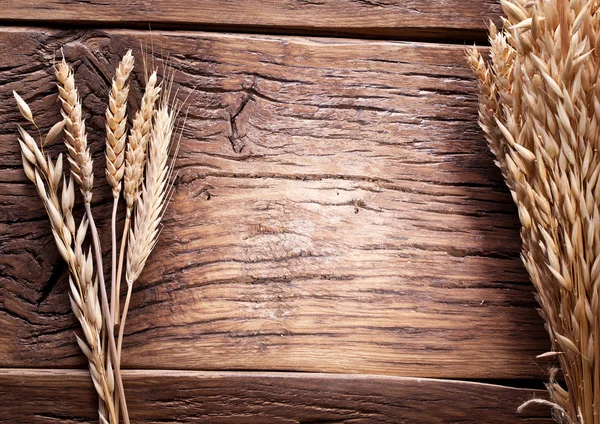 古い木造のテーブルの上に小麦の穂. — ストック写真
