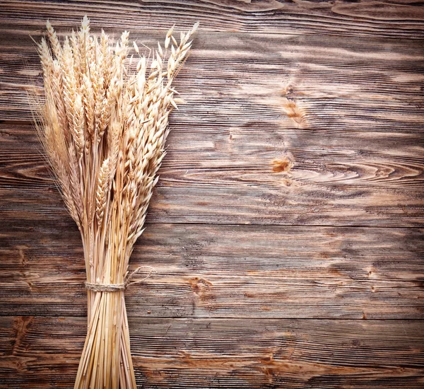 Уши пшеницы на старом деревянном столе . — стоковое фото