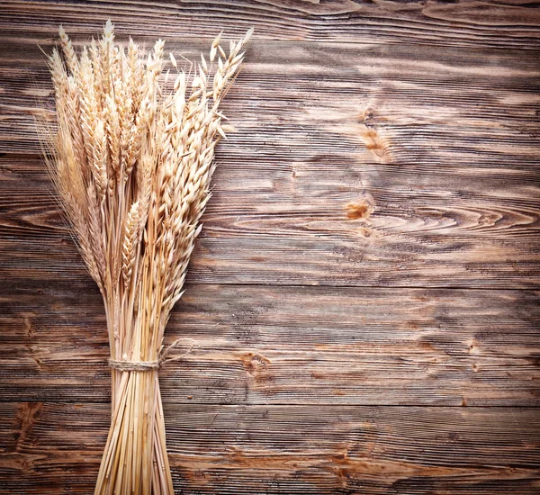 Oreilles de blé sur une vieille table en bois . — Photo