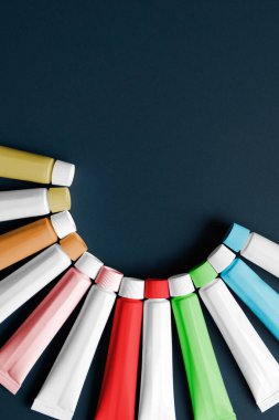 Koyu arkaplan üzerine renkli tüpler konteynırı yarı daire içine yerleştirilmiş ve kopyalama alanı, konsept grafik kaynağı