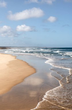 Bir yaz günü Portekiz 'de dalgalar ve bulutlu gökyüzü ile Atlantik Denizi kıyılarının dikey manzarası