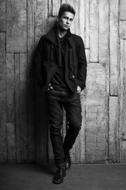 Duvarın yanında duran genç adam