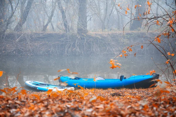 秋の霧の森の小さな川の岸にカヤックやボードアップ — ストック写真
