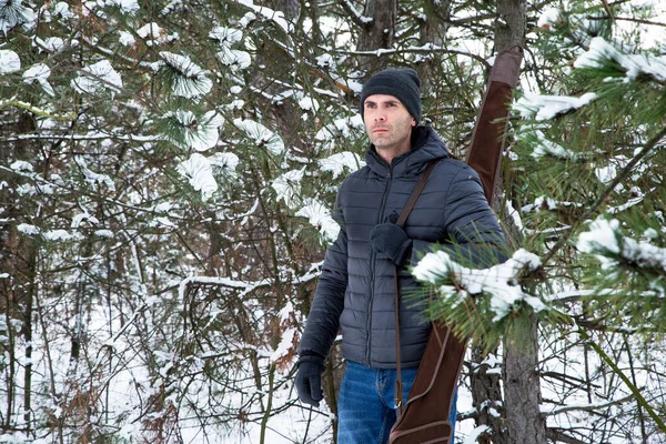 Mężczyzna Kurtce Dżinsach Strzelbą Futerale Ramieniu Zimowym Lesie — Zdjęcie stockowe