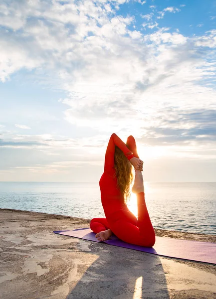 Kobieta Czerwonej Jodze Sprawia Joga Asana Promieniach Słonecznych Pobliżu Morza — Zdjęcie stockowe