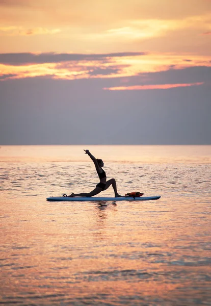 Een Vrouwtje Maakt Yoga Asana Het Sup Board Bij Zonsopgang — Stockfoto