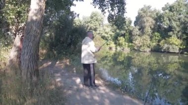 Nehirde bir adam oltayla balık tutuyor.