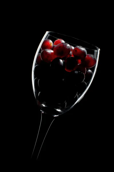 Raisins dans un verre sur fond noir — Photo