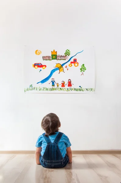 Ребенок смотрит на картинку на стене — стоковое фото