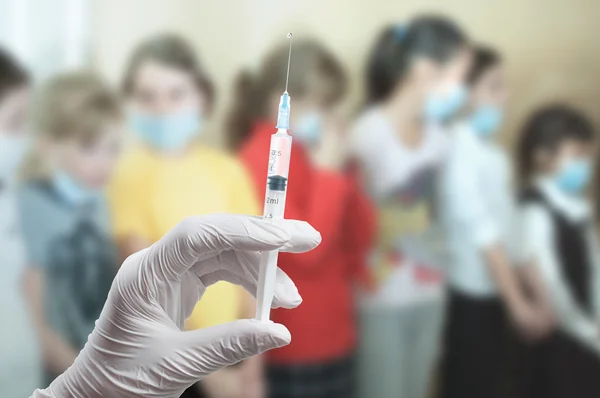 Mão do médico com uma seringa na sala de aula — Fotografia de Stock