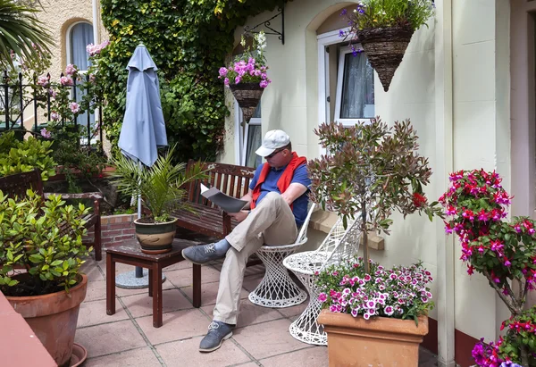 Man reading magazine in home garden — Stock Photo, Image