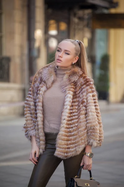 Beautiful young woman with long hair walking in the city — Stock Photo, Image