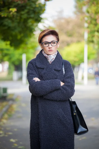 Schöne junge Frau mit Brille, die in der Stadt spaziert, Frühlingsfotos — Stockfoto